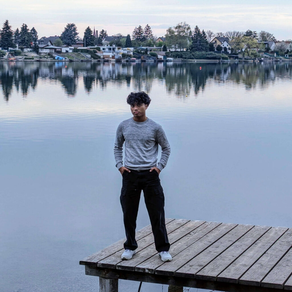 Portrait auf einem Steg mit See im Hintergrund.