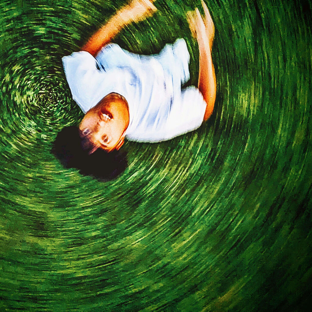 Foto von broizznico mit grüner Wiese im Hintergrund aus Vogelperspektive und einem Overlay-Effekt, der aussieht, wie eine sich schnell drehende Schallplatte.